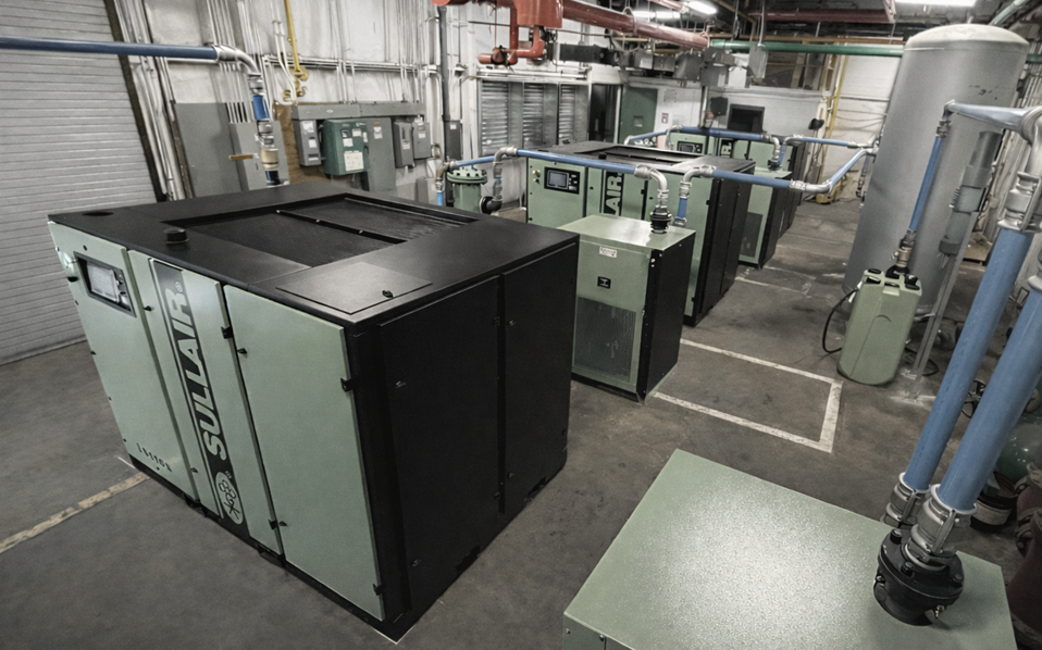 Industrial GMP compressed-air installation with compressors, dryers, air receivers, filtration, drains, and distribution equipment arranged for operation and maintenance.