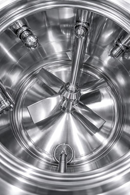Polished interior of a stainless-steel pharmaceutical vessel with agitator, weld transitions, and CIP devices